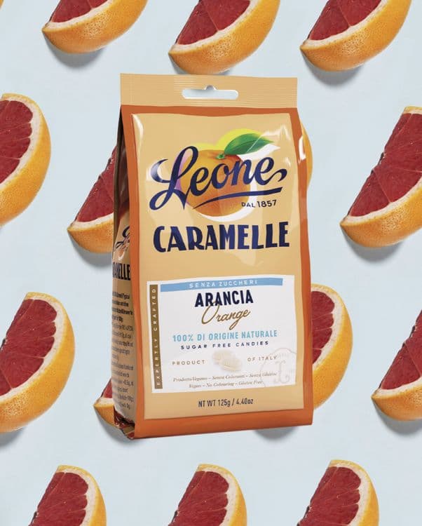 Leone CARAHELLE Arancia Orange candy bag on a blue background with citrus slices.